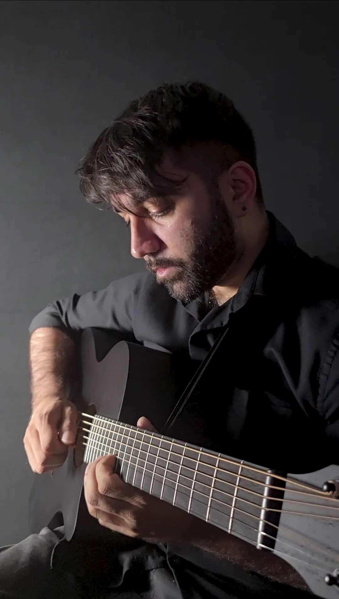 Black acoustic against a black backdrop